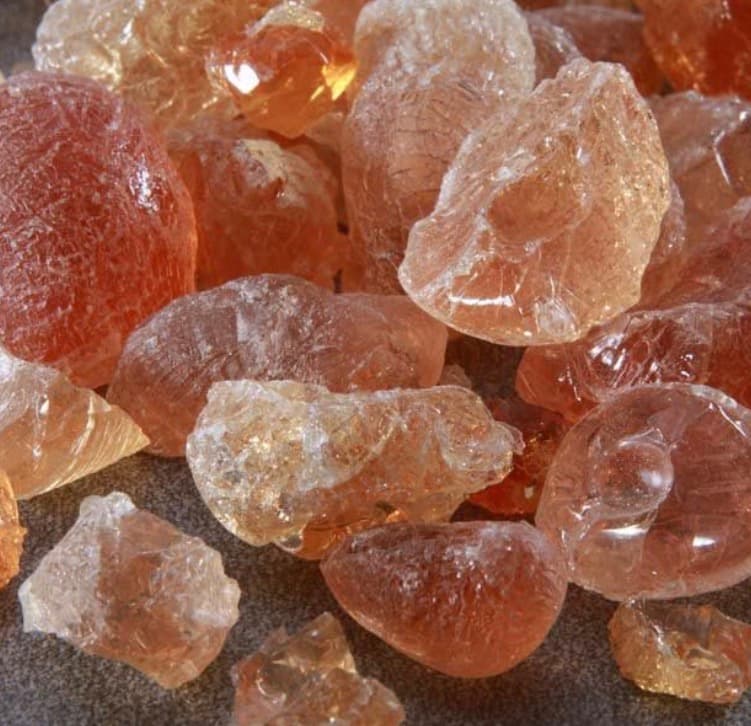 Translucent amber and pale yellow natural resin chunks with rough, crystalline textures in a pile.